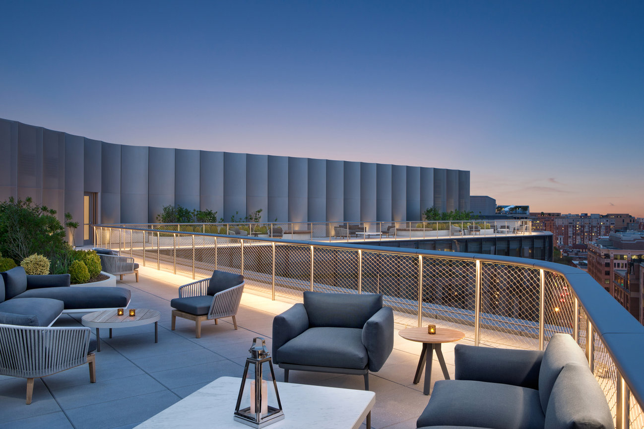 Large Rooftop with beautiful furniture overlooking Washington DC at sunset at the Conrad Hotel.