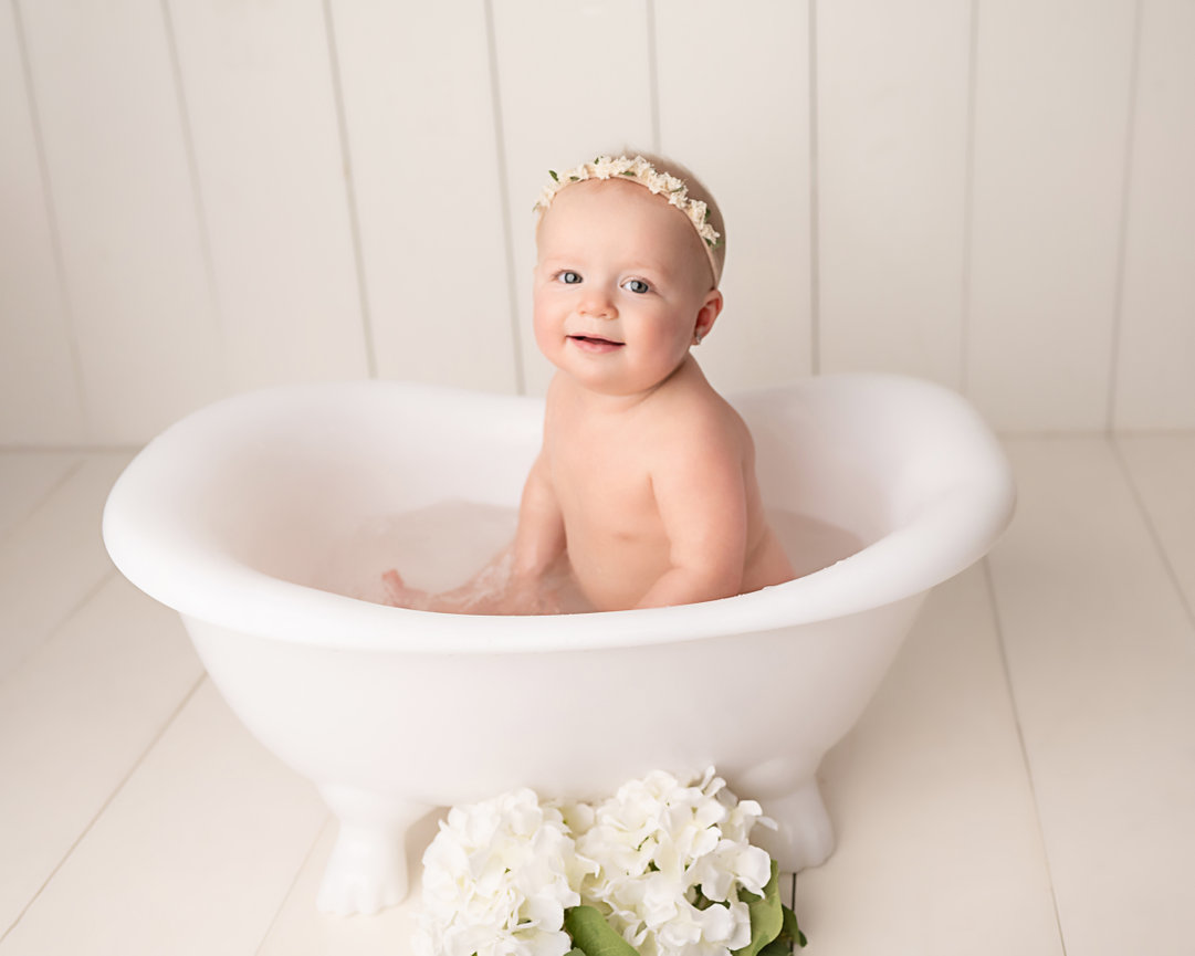 Clean-up time in Westfield: baby smiling while soaking in tiny white tub