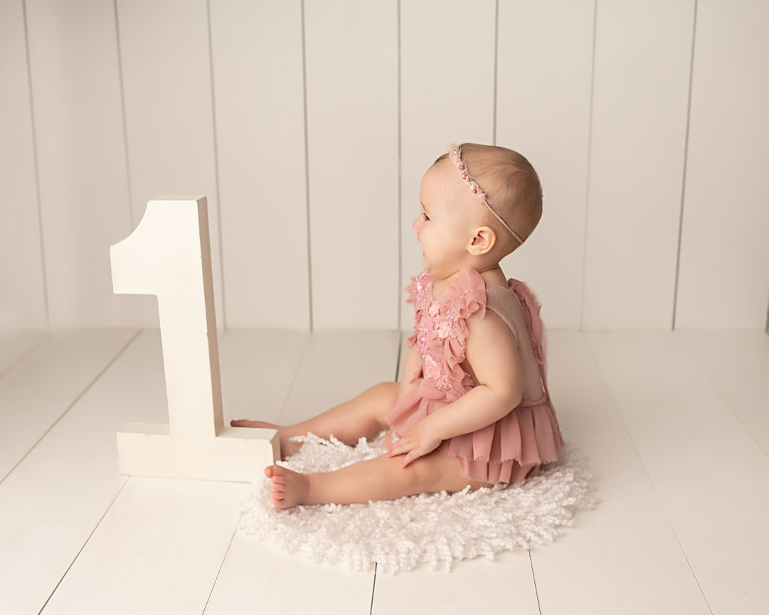 First birthday portrait in Shrewsbury with baby and large number 1 for simple, modern look