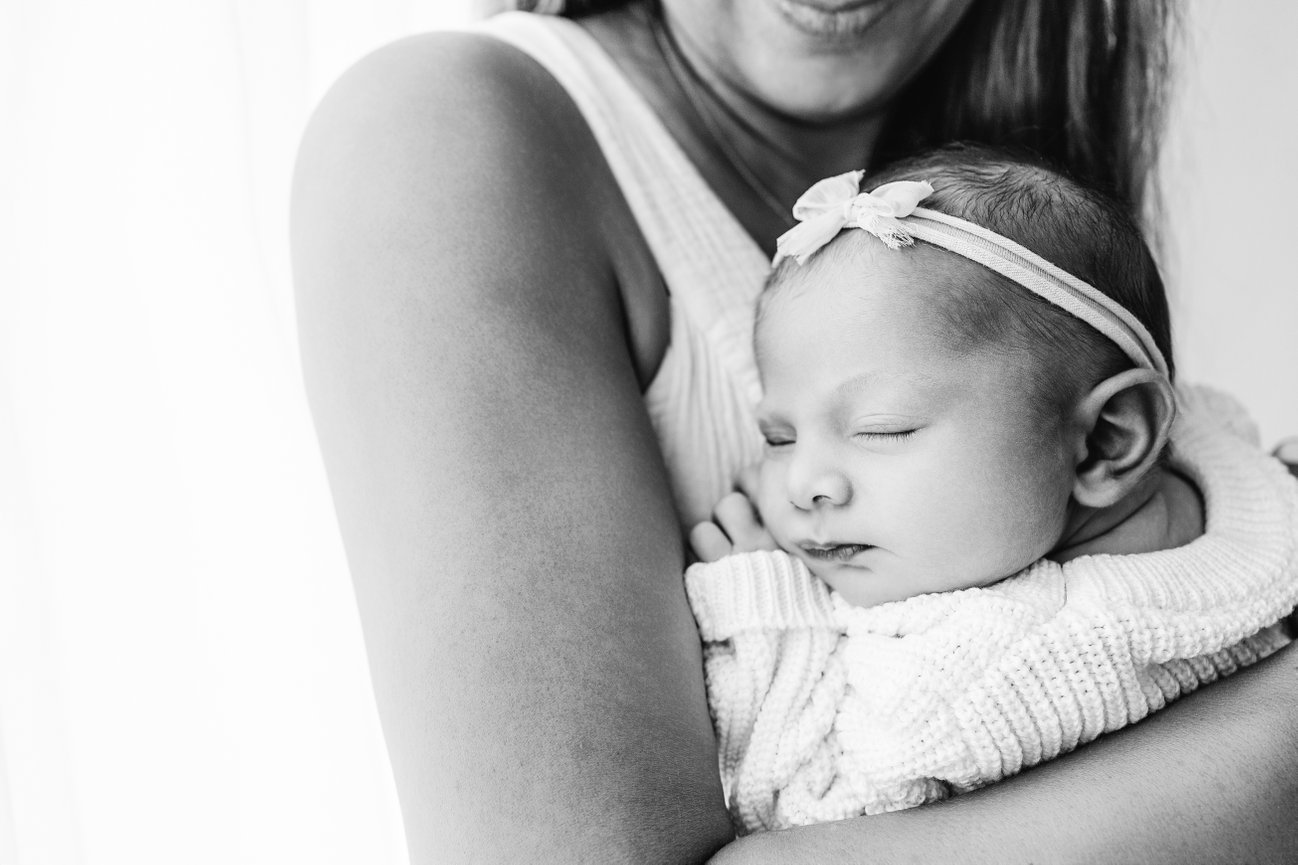Heart-centered portrait of mom and baby cuddling in minimalist Monmouth County studio