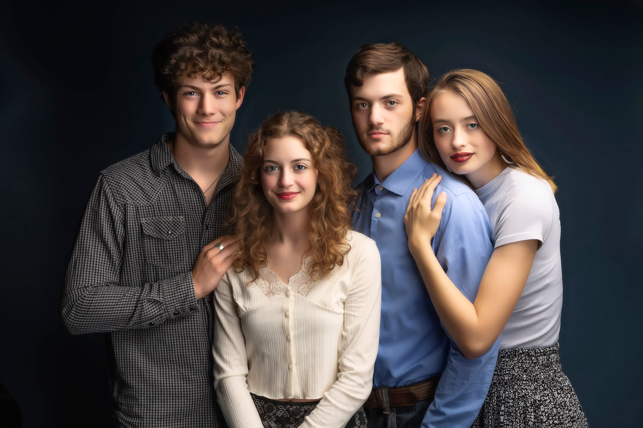 Studio family portrait with group of four in coordinated outfits, captured by Braly Studios in Fort Worth.