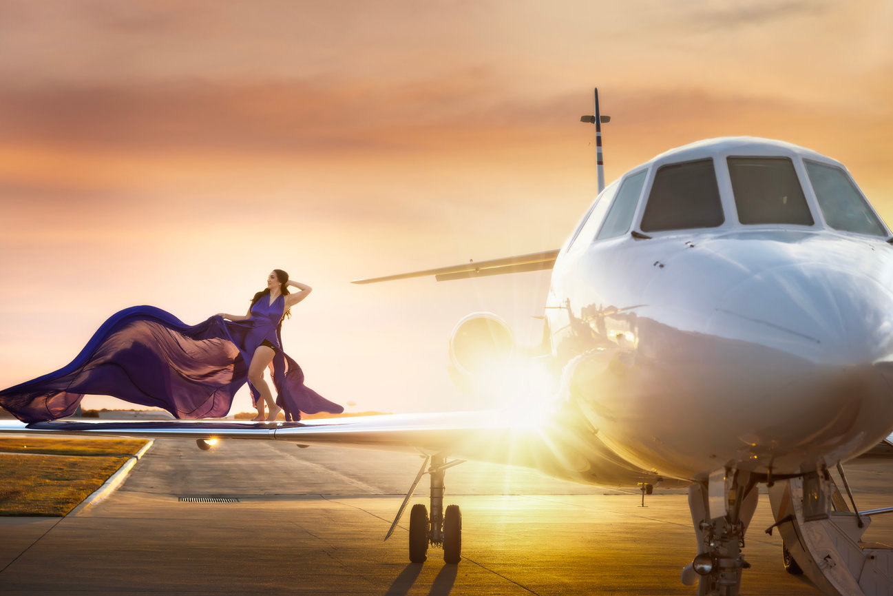 Luxury portrait photography with woman posing beside private jet at sunset in Dallas-Fort Worth.