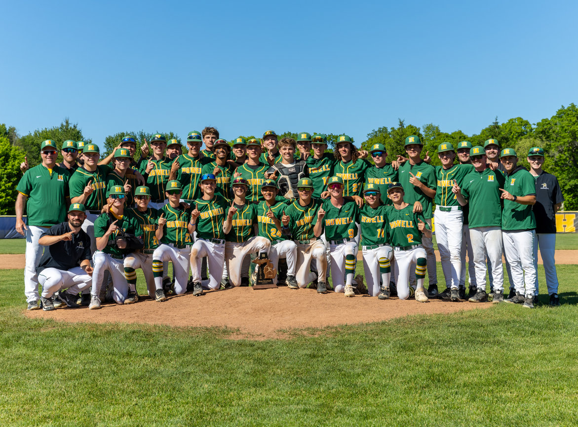 Large baseball team posing together on the field.