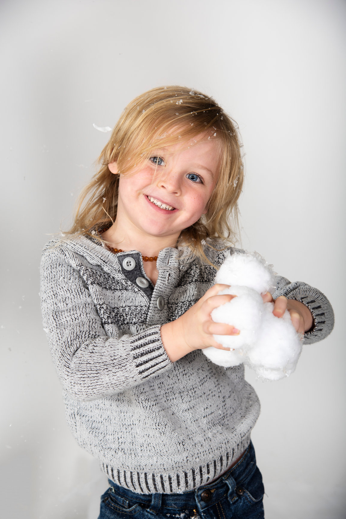 little boy playing with snowballs