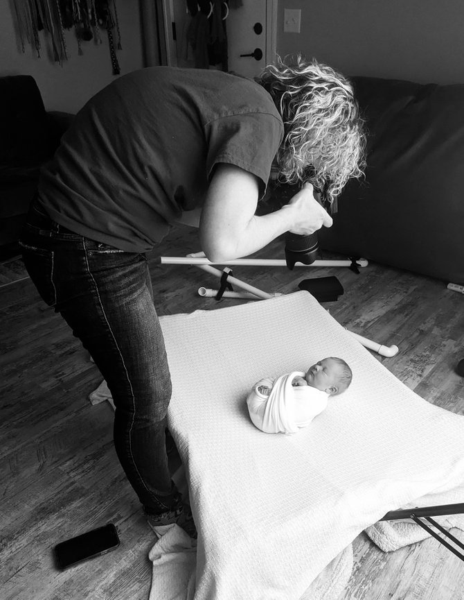 Bennington photographer taking a picture of a swaddled newborn on a blanket.