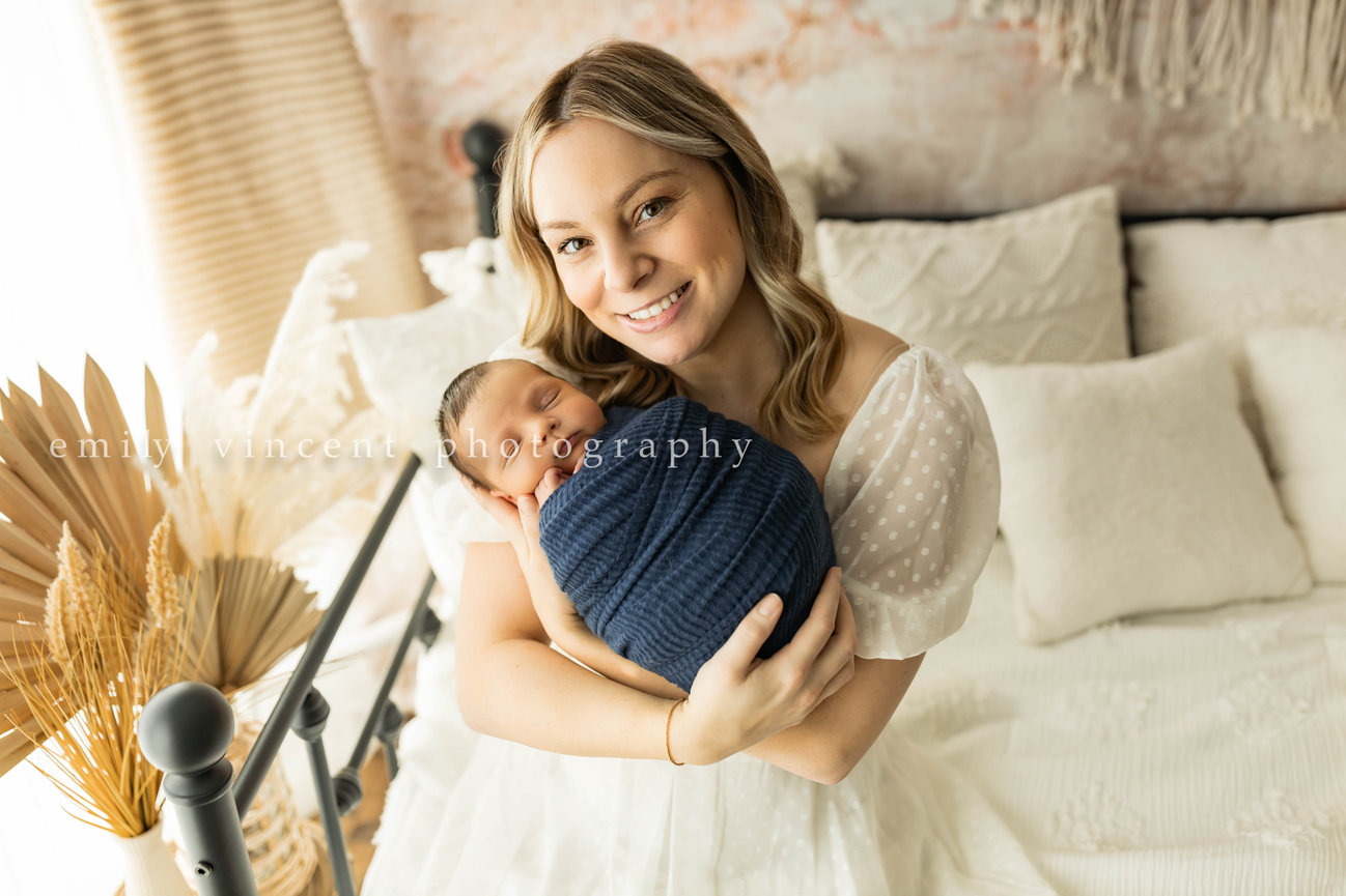 Mother holding sleeping baby close in cozy studio session