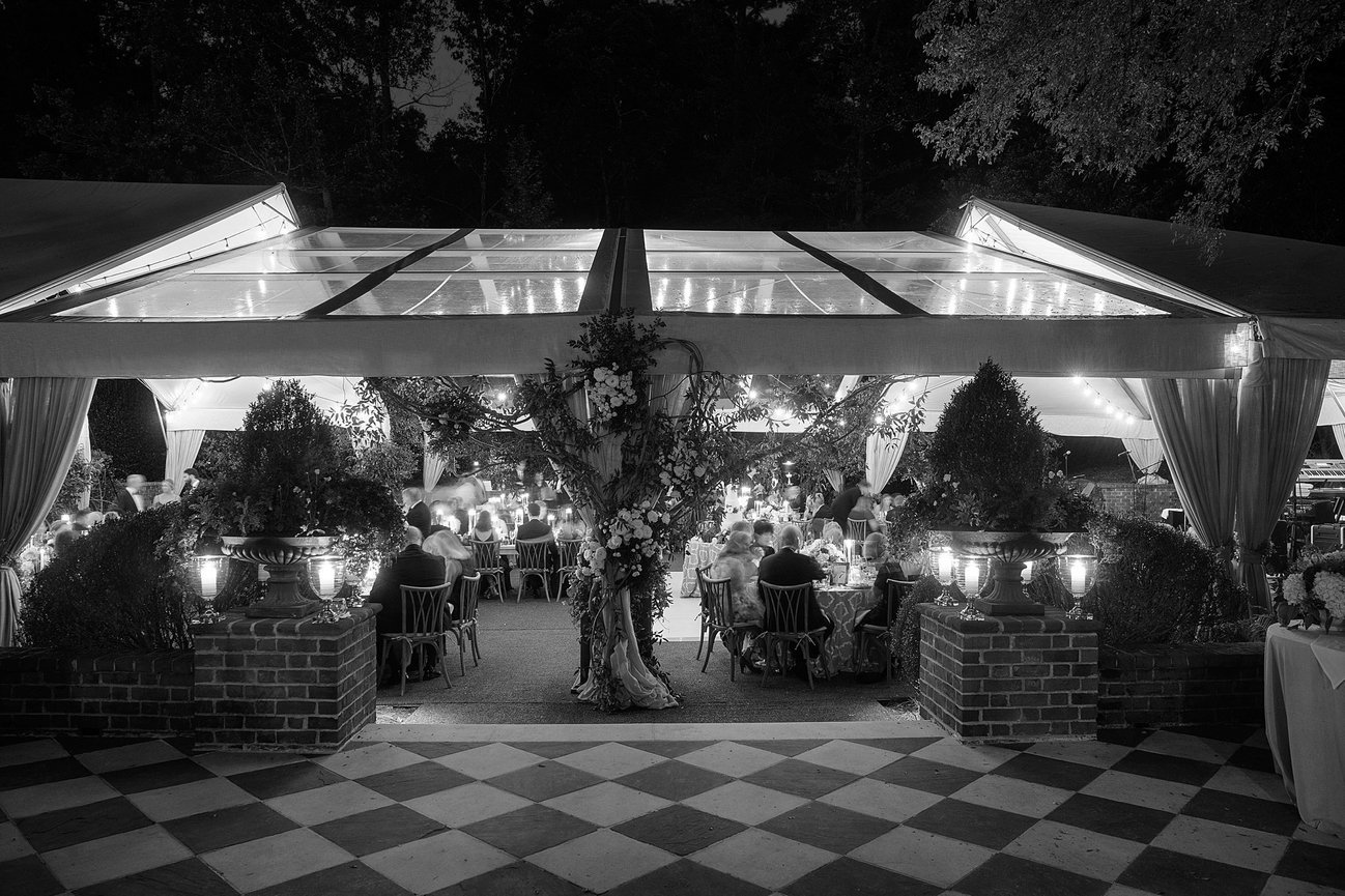 Tented Buckhead Atlanta at-home wedding with candles glowing at seated dinner reception. Private estate wedding photography by Heather Durham.