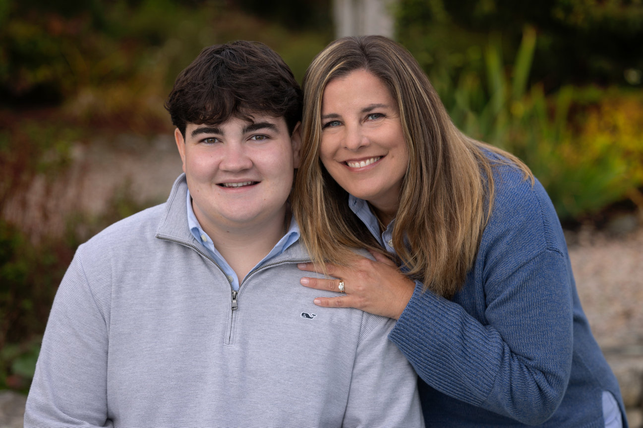 Outdoor family portrait of high school senior boy and mom in garden westwood ma