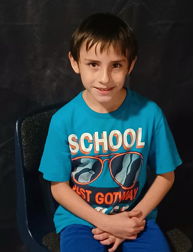 Boy in a blue shirt sitting on a chair